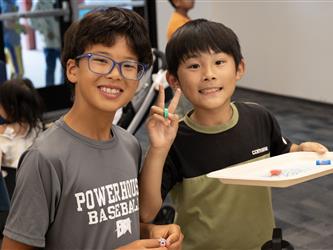 Two boys hold up a project they were completing. 